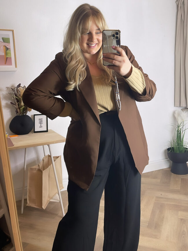 Brauner Blazer, beiges Oberteil, schwarze Hose