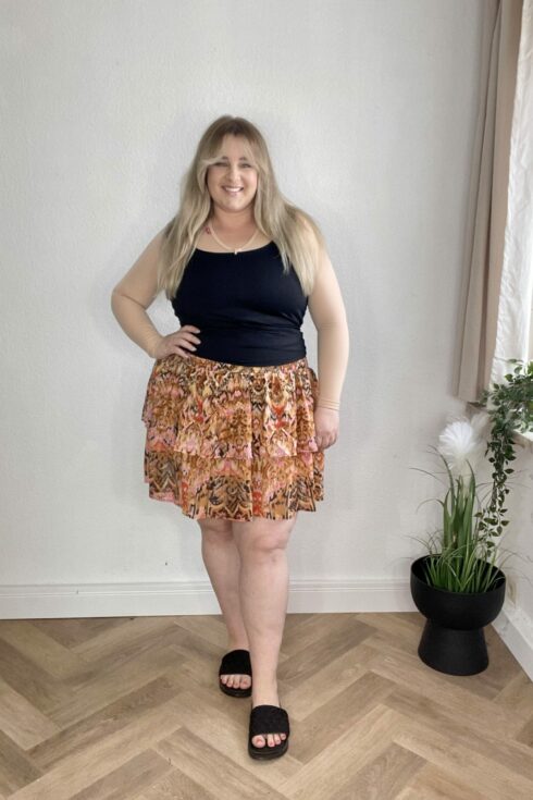 Top Schwarz, Rock mit Blumenmuster, Sandalen Schwarz