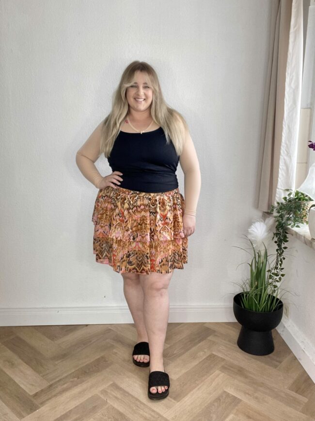 Top Schwarz, Rock mit Blumenmuster, Sandalen Schwarz